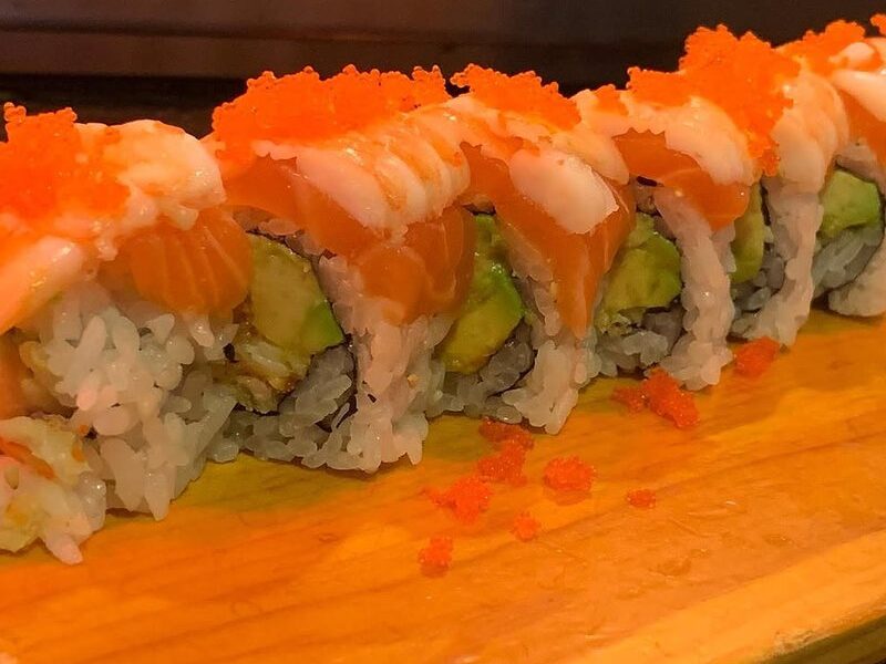 Orange River roll topped with masago on a wooden board